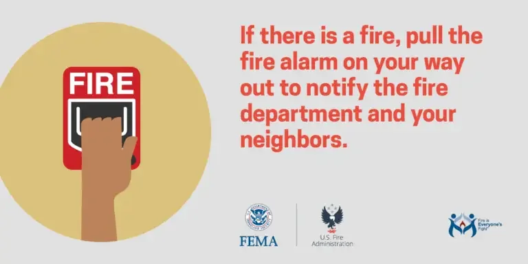 Fire safety awareness: a hand activating a fire alarm for emergency evacuation and notification.
